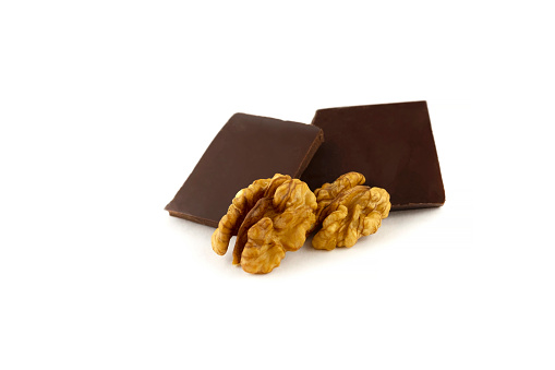 Walnut kernels and two dark chocolate bars isolated on a white background