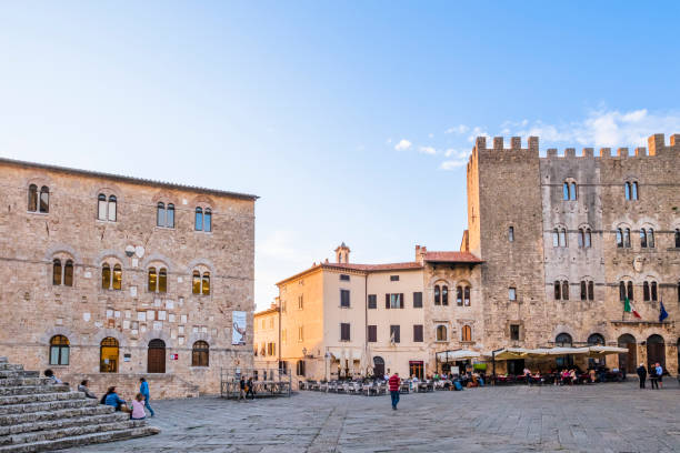 People strolling in the beautiful Piazza Garibaldi in old town of Massa Marittima, where overlooks most of the prominent buildings of the town