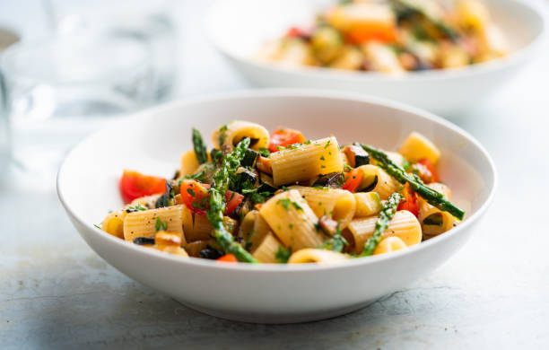 Pasta salad with grilled vegetables, zucchini, eggplant, asparagus and tomatoes. stock photo