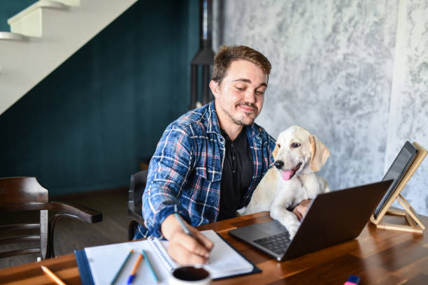 istock Smiling Male Taking Notes About New Brand In Company While Getting Help From His Dog 1401567249