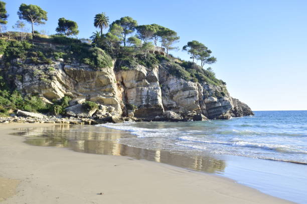 istock Salou, Spain - November 13, 2019: Beautiful sandy beach with a stone cliff 1401567542