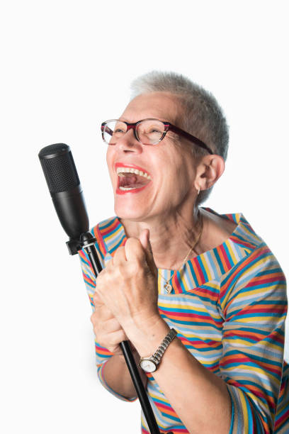 istock Senior old woman singing on a professional microphone 1401567638