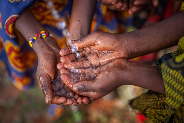 Poor African children keeping their hands up - asking for drinking water.