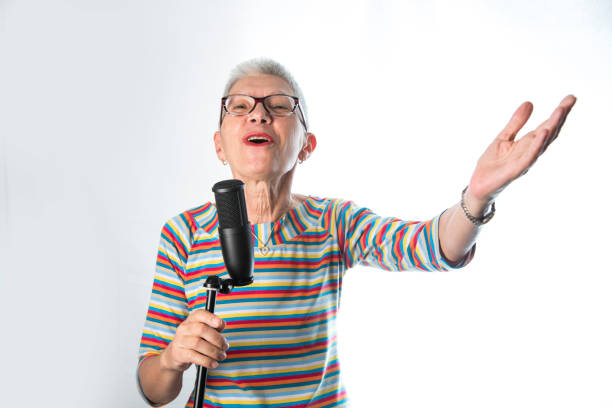 istock Senior old woman singing on a professional microphone 1401568835