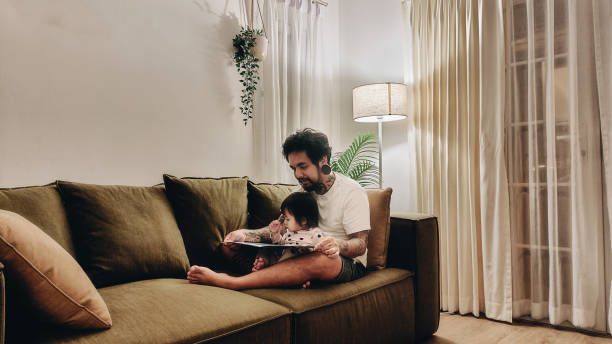 istock Asian father and child, reading a book before bed time. 1401568869