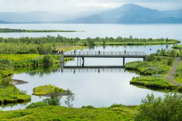 Photo of Tourists on a bridge in  Thingvellir National Park in summer, Iceland