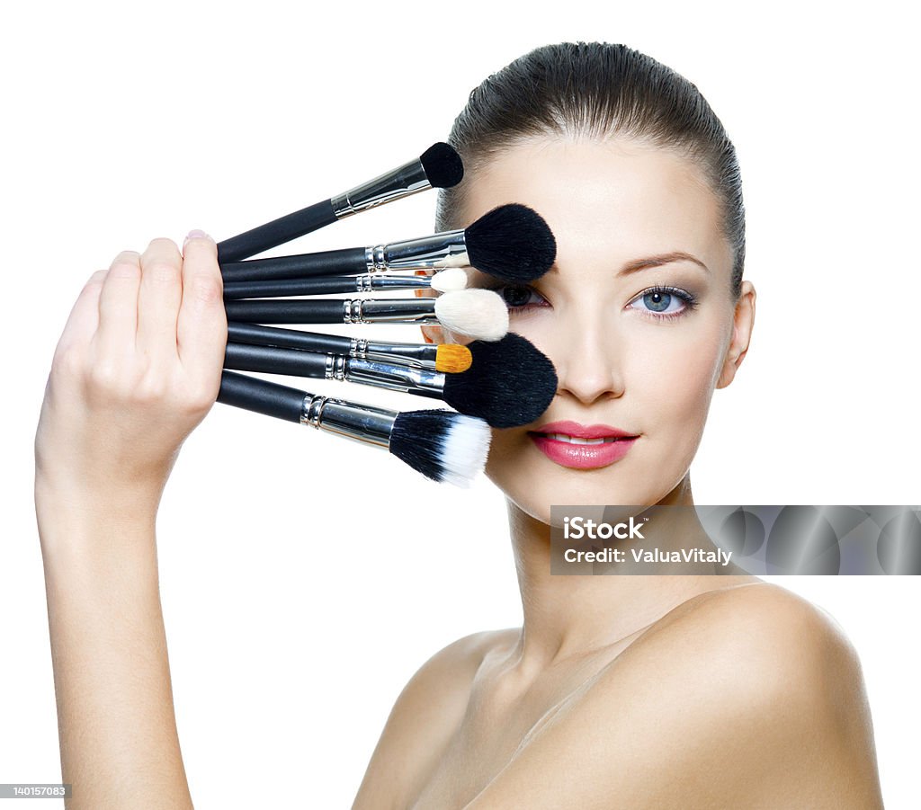 Portrait of the beautiful woman with make-up brushes Portrait of the beautiful woman with make-up brushes near attractive face. Adult girll posing over white background Adult Stock Photo