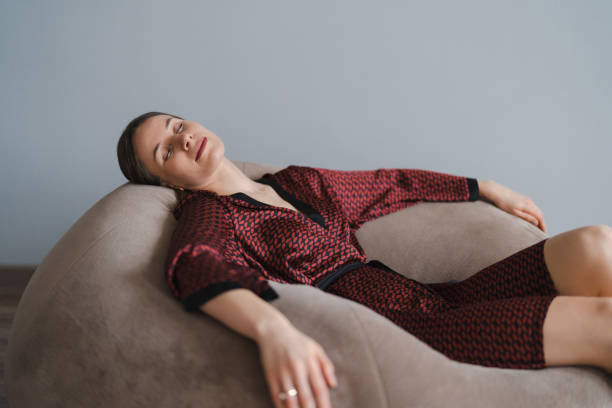 Asleep woman relaxing at home in a beanbag stock photo