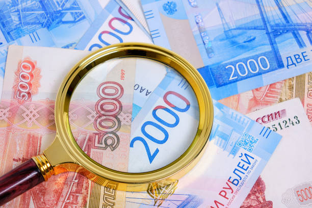 istock Magnifying magnifier against background Russian rubles denominations five and two thousand. 1401575909