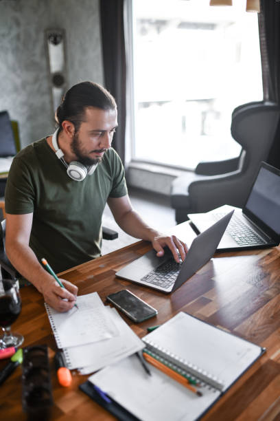 istock Bearded Male Journalist Working From Home And Writing Article 1401575915