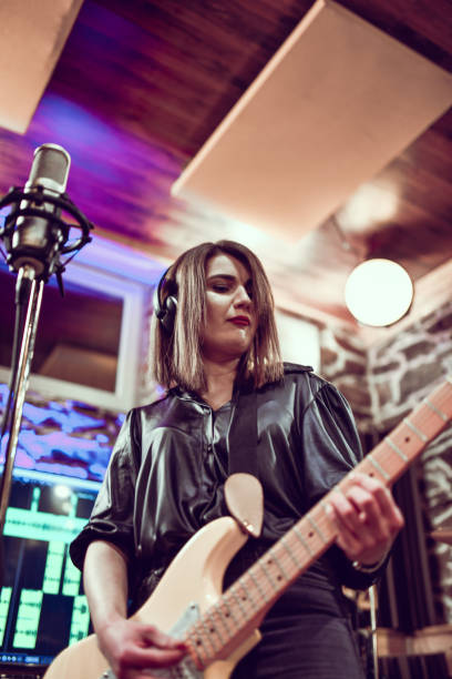 istock Female Guitarist Recording Song In Studio 1401577059