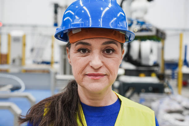 istock Mature woman looking on camera while working inside robotic factory 1401578365
