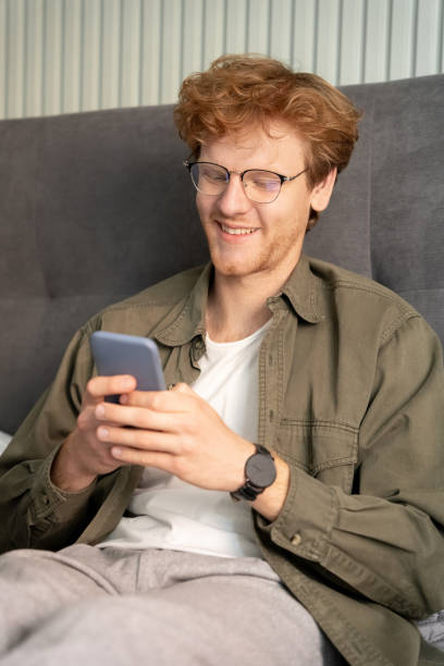 istock Smiling young ginger british man on virtual communication video call using phone 1401578836