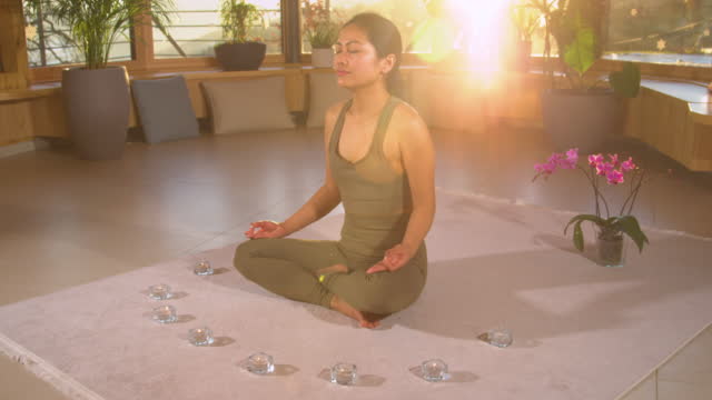 SLOW MOTION: Meditating beautiful Asian woman practicing breathing technique