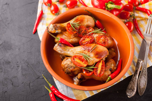 istock the baked chicken legs with a tomato in a bowl on a table, selective focus, copy space 1401582990