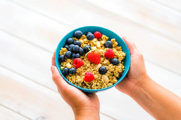 istock Hands holding granola and berries bowl 1401584263