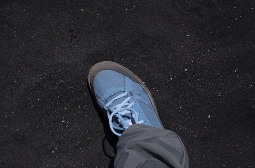 La Palma, Black volcanic ash covering the ground around Volcanoes Route, hiking boot for contrast