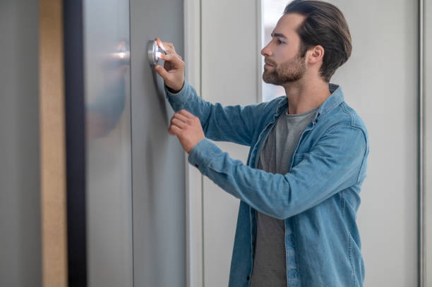 istock Man standing sideways to camera touching wall indoors 1401587398