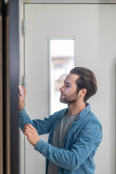 istock Man looking at wall touching hand indoors 1401587401