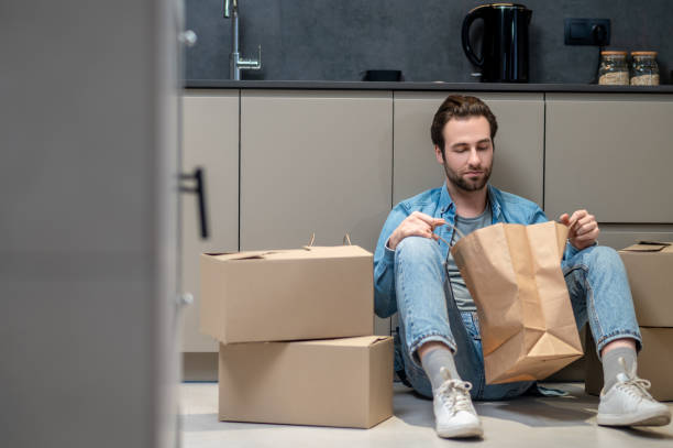 istock Man looking into bag sitting on floor 1401587423