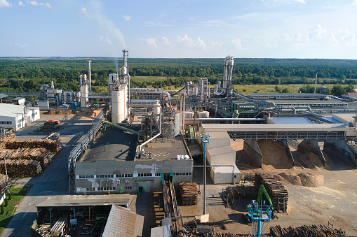 Aerial view of wood processing factory with stacks of lumber at plant manufacturing yard.