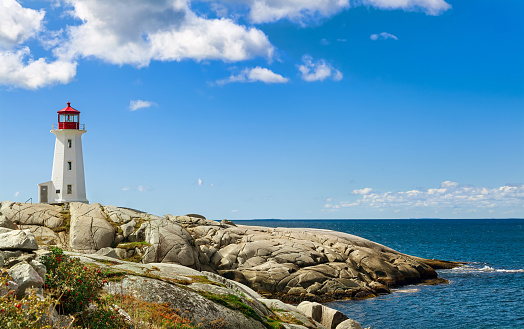 Panorama of harbor with Nova Scotia's iconic Peggys Cove Lighthouse on a sunny day