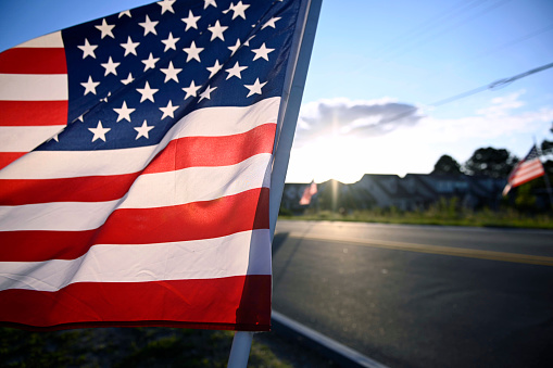 USA Flag in foreground, outside community in background.