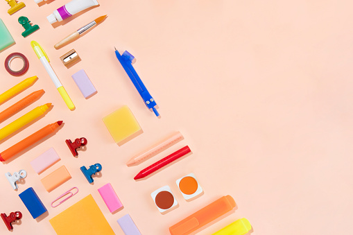Pink background and variety of school supplies.