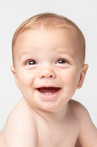 A close up of a happy 9 month old baby boy's face.