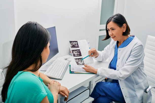 mulher adulta recebendo consulta nos resultados do exame e ovários ultrassom de seu ginecologista. ginecologia e tratamento de doenças ginecológicas - gynecologist ultrasound human pregnancy gynecological examination - fotografias e filmes do acervo