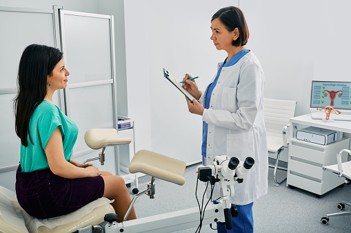 Young woman during appointment with mature gynecologist at gynecology clinic. Women's health, examination of uterus and ovarian