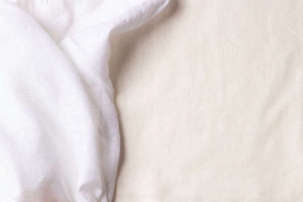 istock White crumpled linen fabric texture background. Natural linen organic eco textiles canvas background. Two shades of white color linen cloth material. Top view, copy space 1401597640
