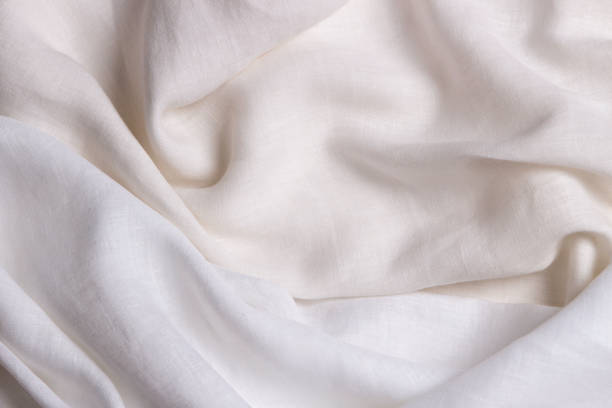 istock White crumpled linen fabric texture background. Natural linen organic eco textiles canvas background. Two shades of white color linen cloth material. Top view, copy space 1401597670