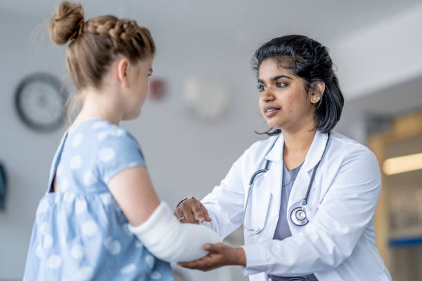 istock Surgeon Evaluating a Little Girls Broken Arm 1401597793