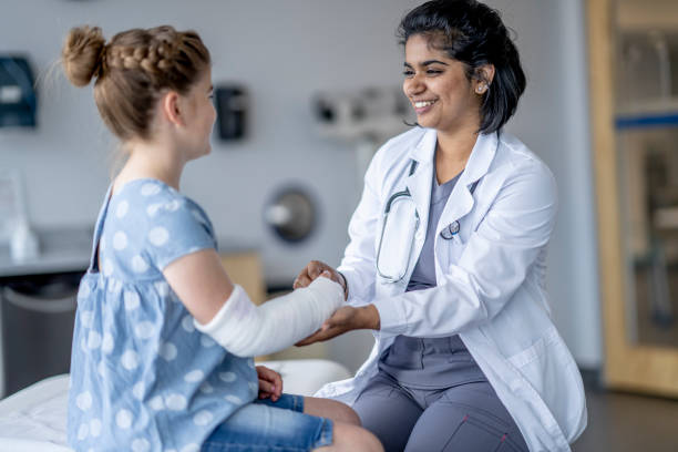 istock Surgeon Evaluating a Little Girls Broken Arm 1401597797