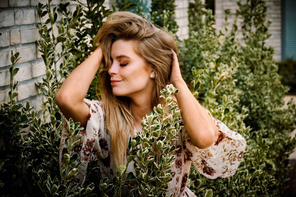 Pretty woman having fun outdoors in city. Close-up portrait of blond woman with long hair