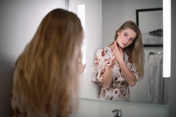 istock Woman in bathroom looking at mirror 1401601152
