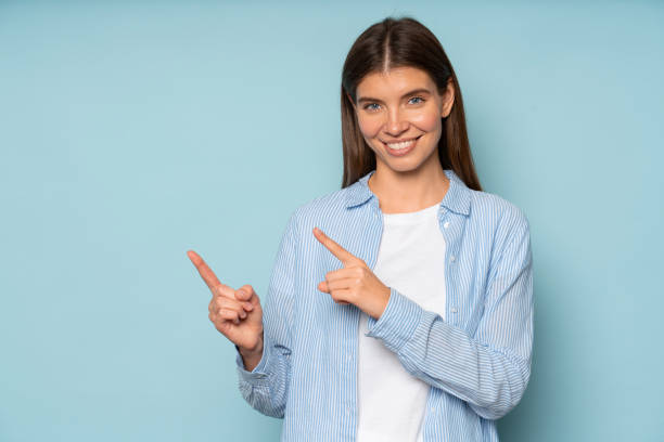 istock Happy positive woman pointing index fingers aside on copy space 1401601766
