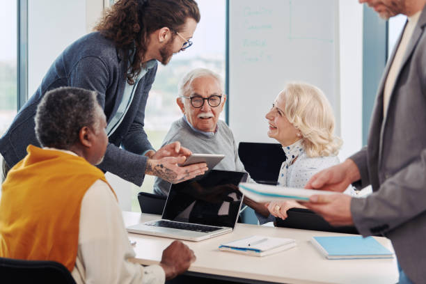 istock A young educator in a classroom with senior students shows on tablet lecture. 1401602544