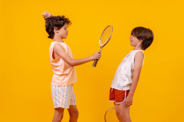 istock Two kids playing tennis and having fun, yellow background 1401610391