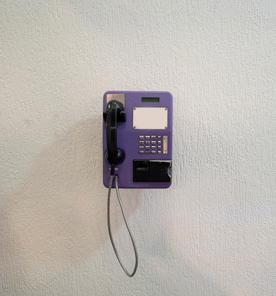 Public telephone on white wall