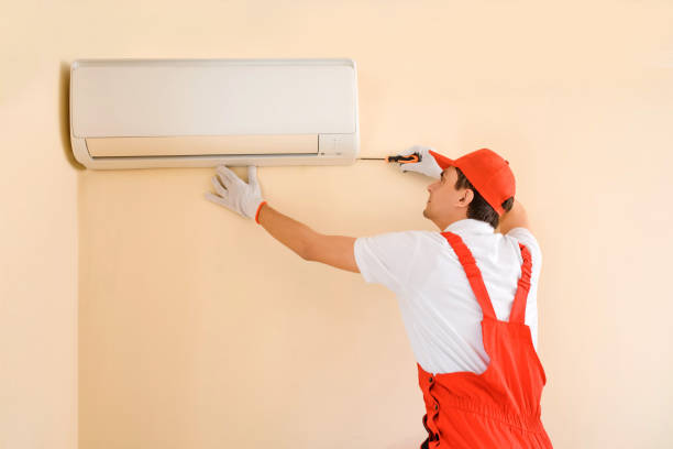 istock Man professional technician in red overall fixing the AC air conditioner 1401614829