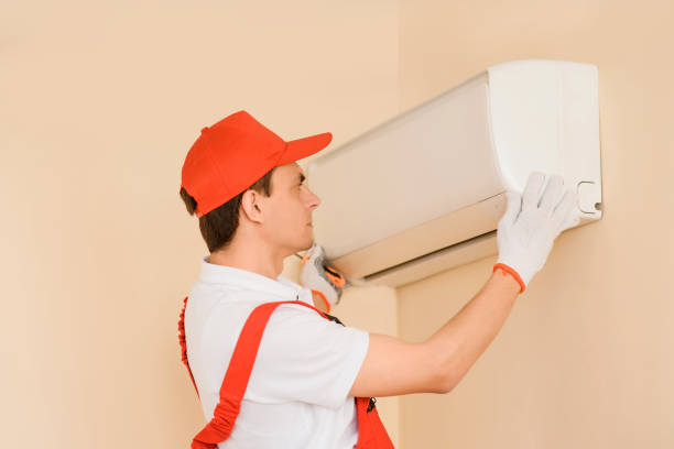 istock Man professional technician in red overall fixing the AC air conditioner 1401614852