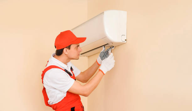 istock Man professional technician in red overall fixing the AC air conditioner 1401614867