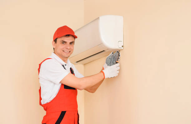 istock Man professional technician in red overall fixing the AC air conditioner 1401614873