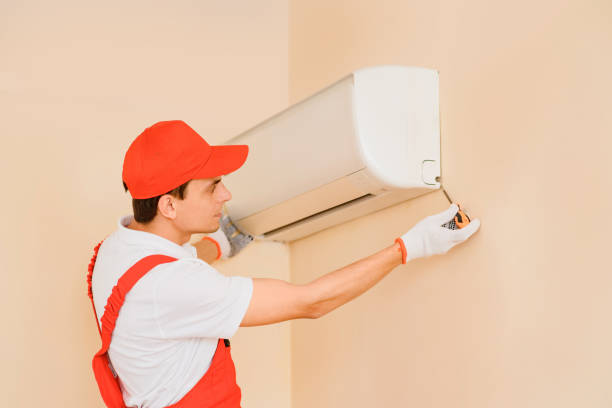 istock Man professional technician in red overall fixing the AC air conditioner 1401614875