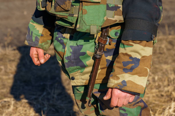 istock Bayonet knife on a military belt. Background with selective focus and copy space 1401618785