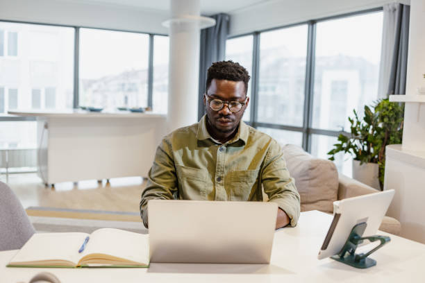 istock African-American man working on laptop at home 1401621061