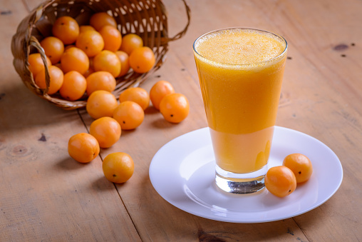 Glass of organic orange juice on wooden table