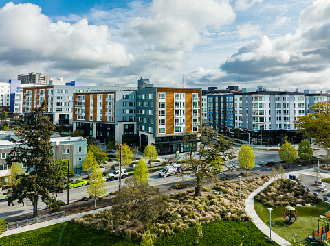 Multi-Family Housing in Seattle's Yesler Terrace.  A park is in the foreground and white fluffy spring clouds are in the top of the photo.